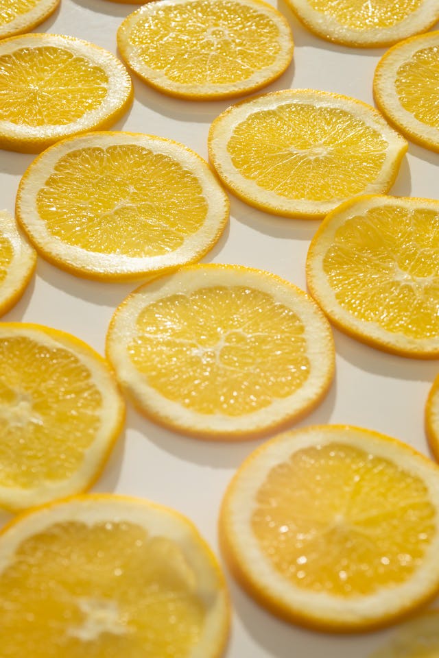 Sliced lemons lay flat on a white surface.